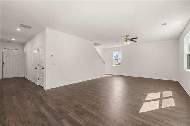 unfurnished living room with a ceiling fan, dark wood finished floors, baseboards, and visible vents