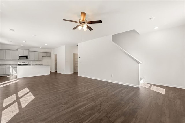 unfurnished living room featuring baseboards, dark wood-style floors, ceiling fan, and recessed lighting