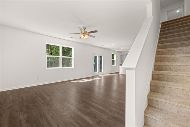 interior space with a ceiling fan, plenty of natural light, baseboards, and wood finished floors