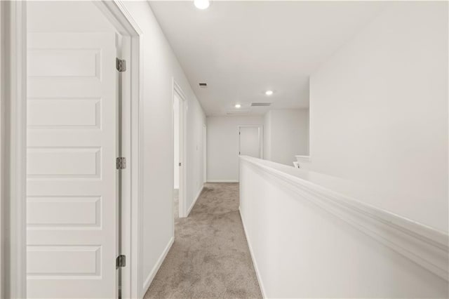 corridor with light carpet, baseboards, visible vents, and recessed lighting