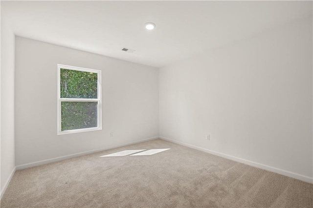 carpeted spare room featuring baseboards and visible vents