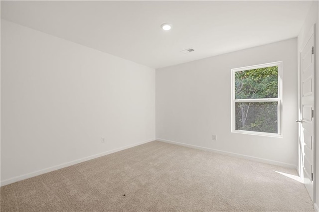 unfurnished room with light carpet, baseboards, and visible vents