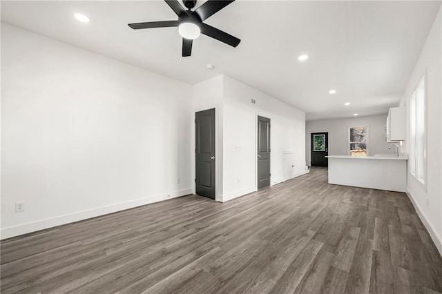 unfurnished living room featuring hardwood / wood-style floors, ceiling fan, and sink