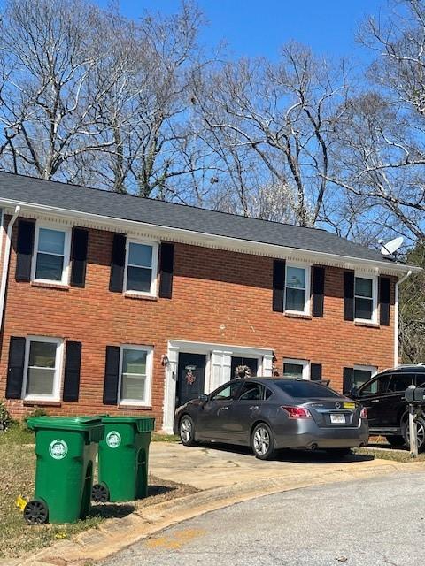 view of front of property featuring brick siding and driveway