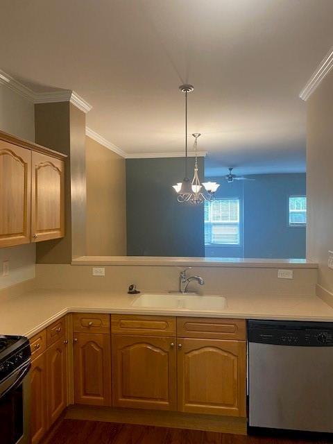 kitchen with light countertops, stainless steel dishwasher, a sink, and pendant lighting