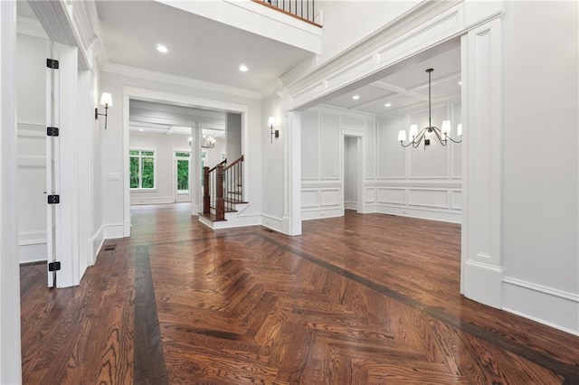 foyer featuring recessed lighting, a decorative wall, stairs, ornamental molding, and an inviting chandelier