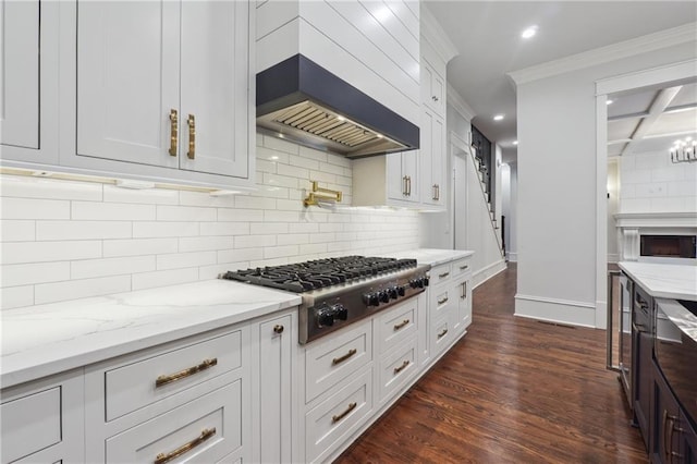 kitchen with stainless steel gas cooktop, white cabinetry, custom exhaust hood, dark wood-style floors, and crown molding