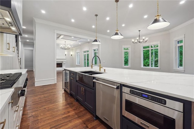 kitchen with appliances with stainless steel finishes, open floor plan, light stone countertops, crown molding, and wall chimney range hood