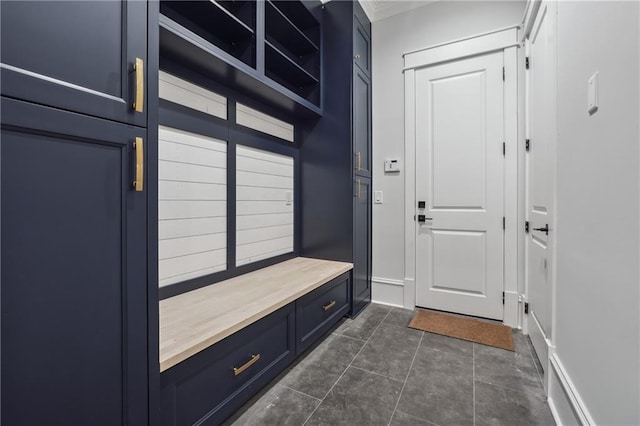 mudroom with dark tile patterned flooring