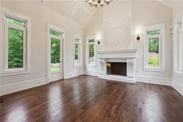 unfurnished living room featuring a fireplace with raised hearth, dark wood-type flooring, a chandelier, and baseboards