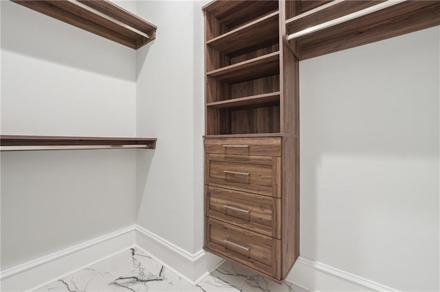 walk in closet with marble finish floor