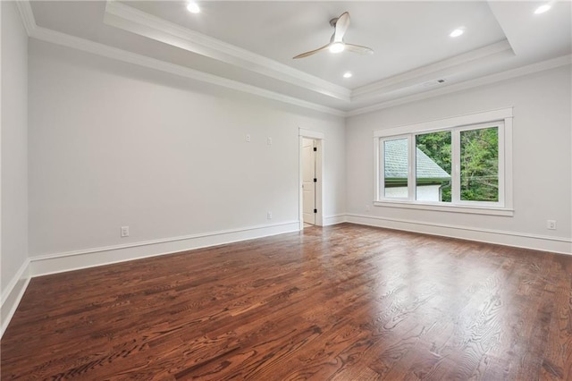 unfurnished room featuring dark wood-style floors, baseboards, a raised ceiling, and crown molding