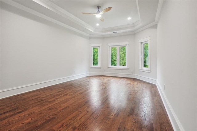 spare room with baseboards, a raised ceiling, ornamental molding, dark wood-style flooring, and recessed lighting