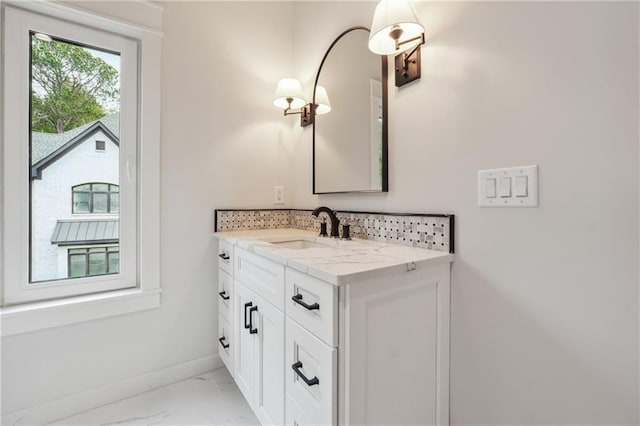 bathroom featuring marble finish floor, vanity, and baseboards