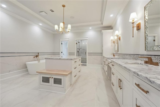 bathroom featuring marble finish floor, a tray ceiling, a freestanding bath, crown molding, and a shower stall