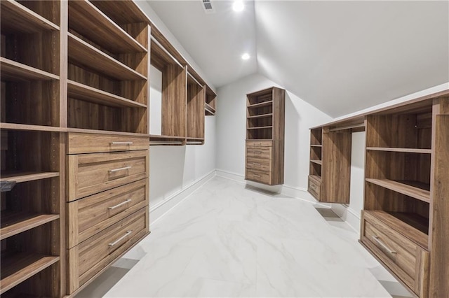 walk in closet with lofted ceiling, marble finish floor, and visible vents