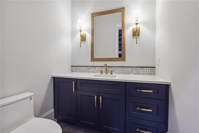 half bathroom with toilet, tasteful backsplash, and vanity