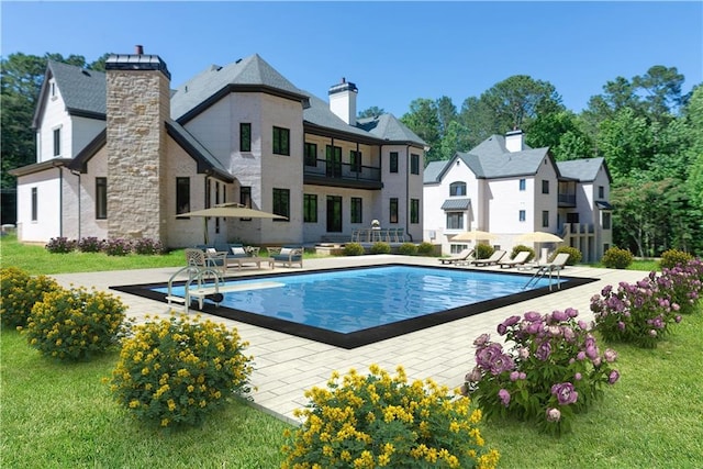 back of property with an outdoor pool, a patio, a balcony, a chimney, and a yard