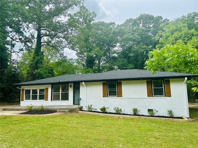 ranch-style house featuring brick siding and a front yard
