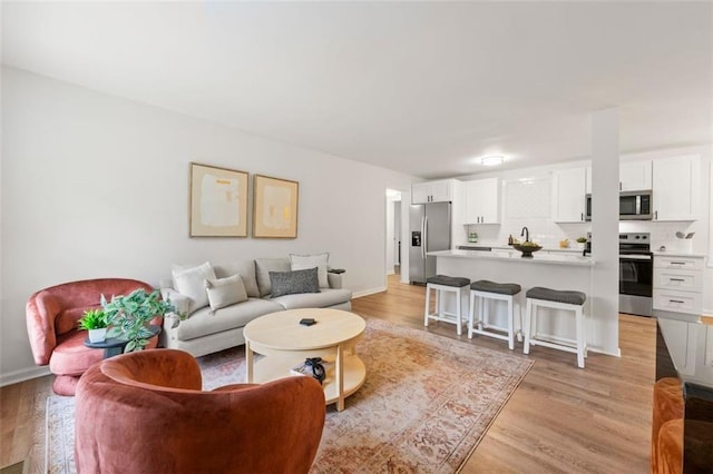 living room with baseboards and light wood-type flooring