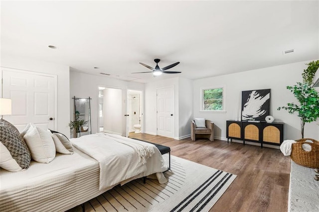 bedroom featuring connected bathroom, ceiling fan, baseboards, wood finished floors, and visible vents