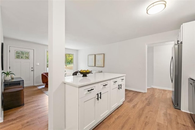 kitchen with baseboards, freestanding refrigerator, light wood finished floors, and white cabinetry