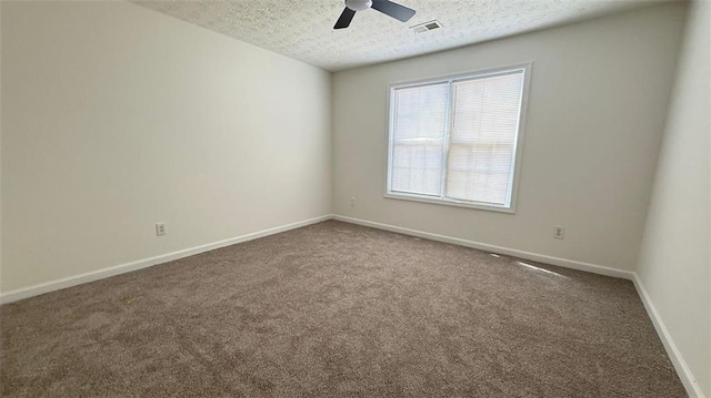 empty room with carpet, visible vents, ceiling fan, a textured ceiling, and baseboards