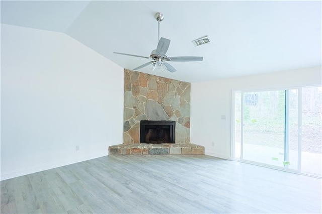 unfurnished living room with a stone fireplace, vaulted ceiling, ceiling fan, and light wood-type flooring