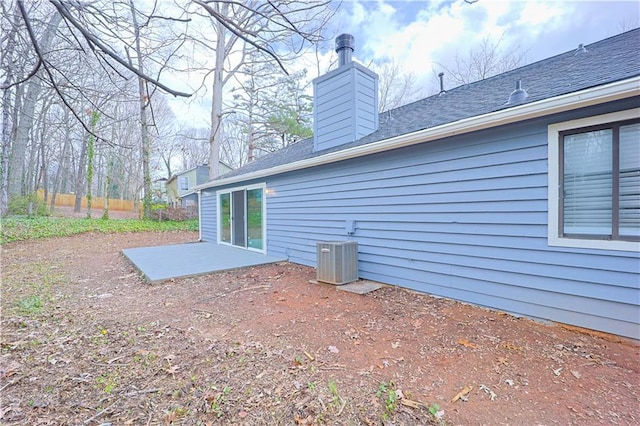 back of property with central AC unit and a patio area