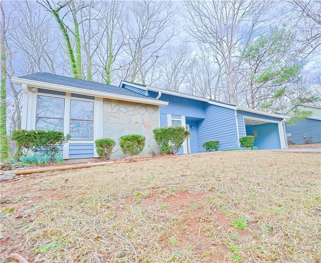 single story home with a garage and a front lawn