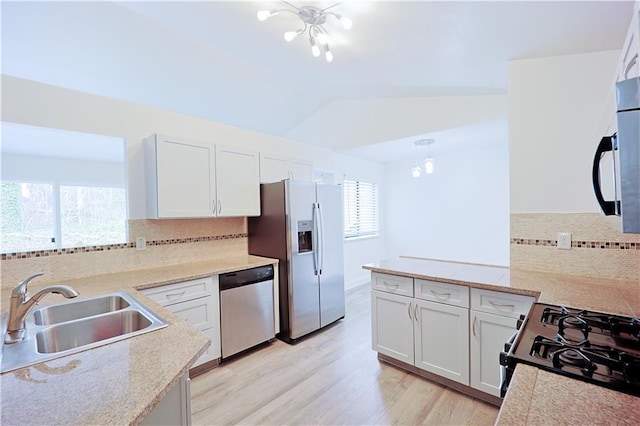 kitchen with white cabinetry, appliances with stainless steel finishes, vaulted ceiling, and sink