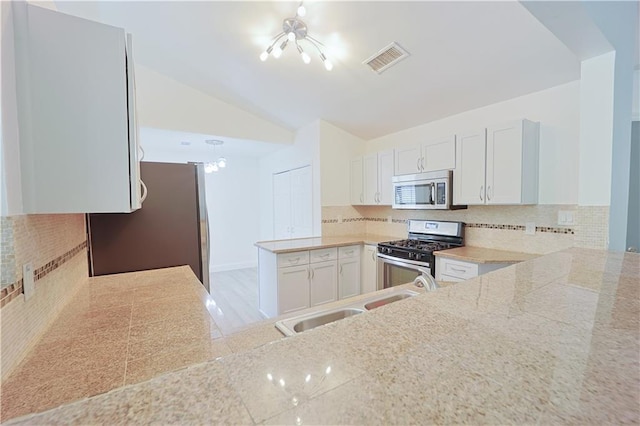 kitchen featuring white cabinetry, appliances with stainless steel finishes, sink, and backsplash