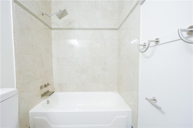 bathroom featuring tiled shower / bath and toilet