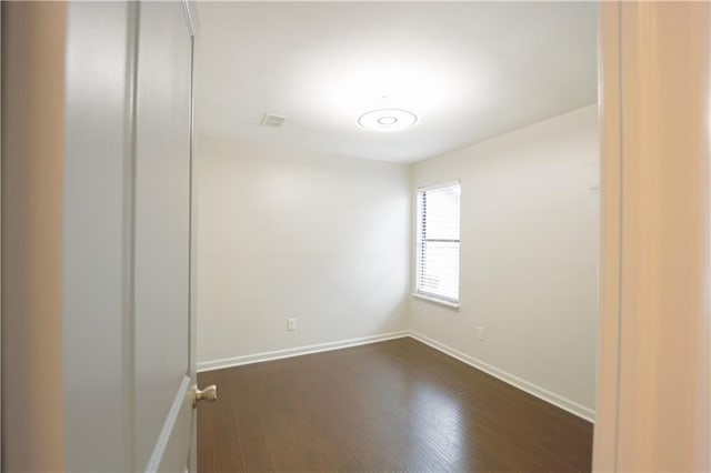 unfurnished room with dark wood-type flooring