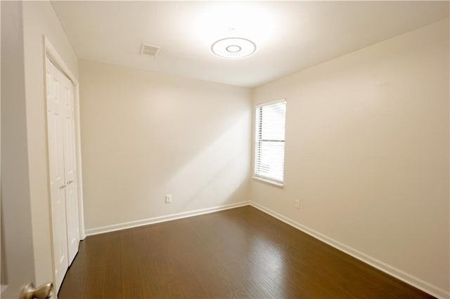 unfurnished bedroom featuring a closet and dark hardwood / wood-style floors