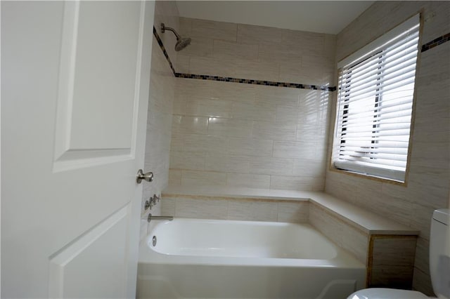 bathroom with tiled shower / bath and toilet