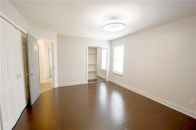 unfurnished bedroom with a closet and dark hardwood / wood-style floors