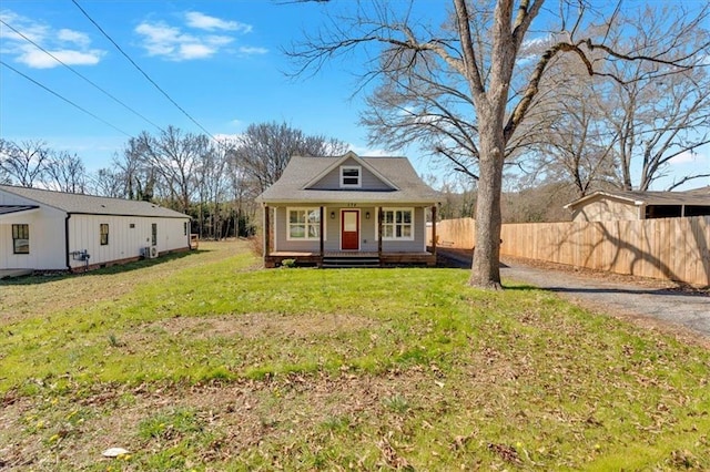 view of front facade with a porch, a front lawn, and fence