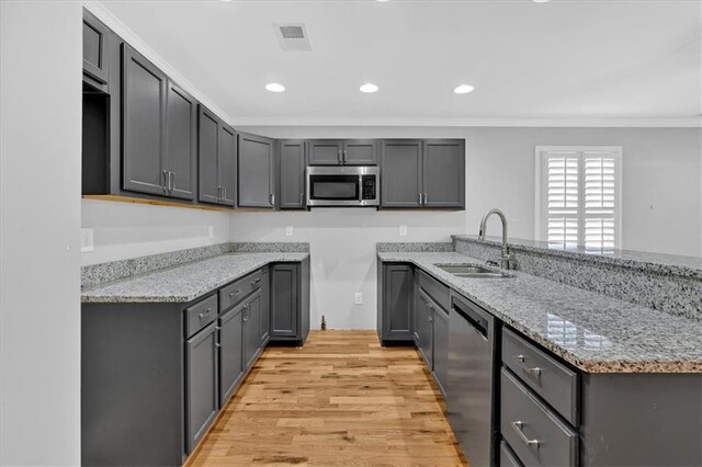 kitchen featuring light stone counters, recessed lighting, visible vents, light wood-type flooring, and stainless steel microwave