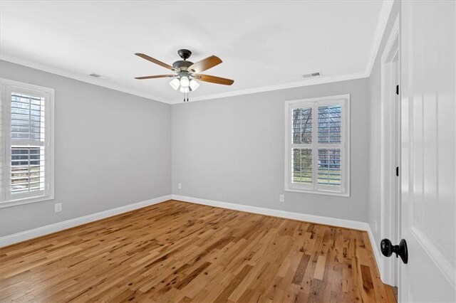 unfurnished bedroom with light wood-style flooring, crown molding, visible vents, and baseboards