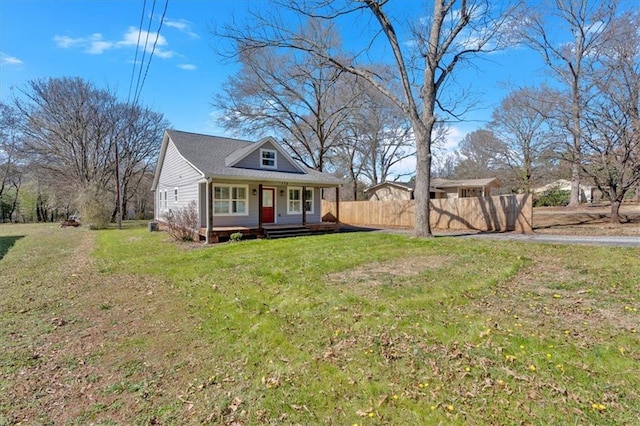 bungalow-style house with a front yard, covered porch, and fence