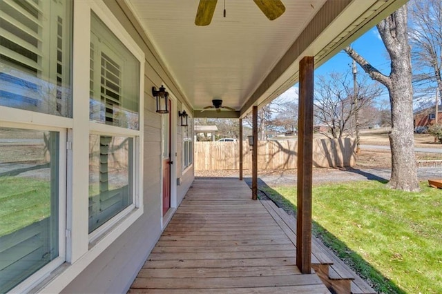 wooden terrace with a ceiling fan and fence