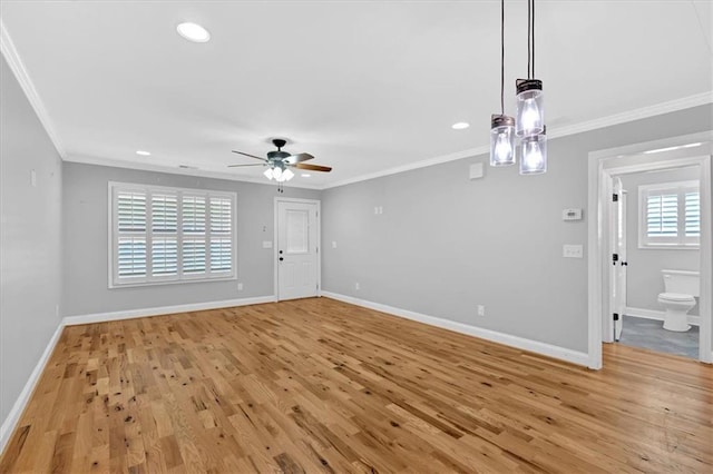 interior space featuring ornamental molding, light wood-style flooring, and baseboards