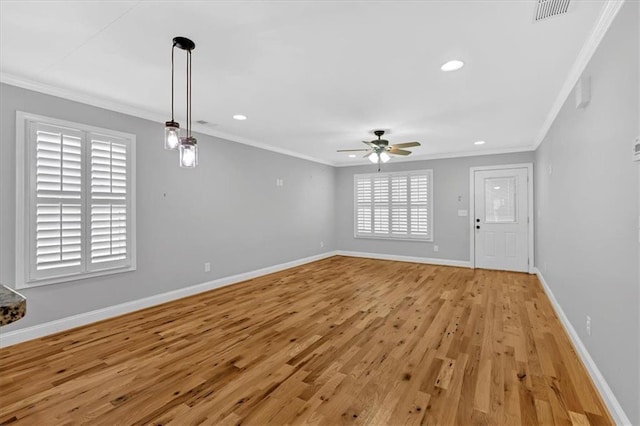 unfurnished living room with light wood finished floors, visible vents, baseboards, and crown molding