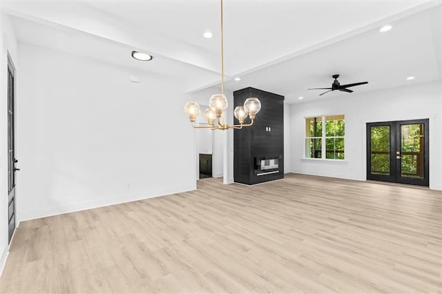 unfurnished living room with french doors, light hardwood / wood-style flooring, a fireplace, and ceiling fan with notable chandelier