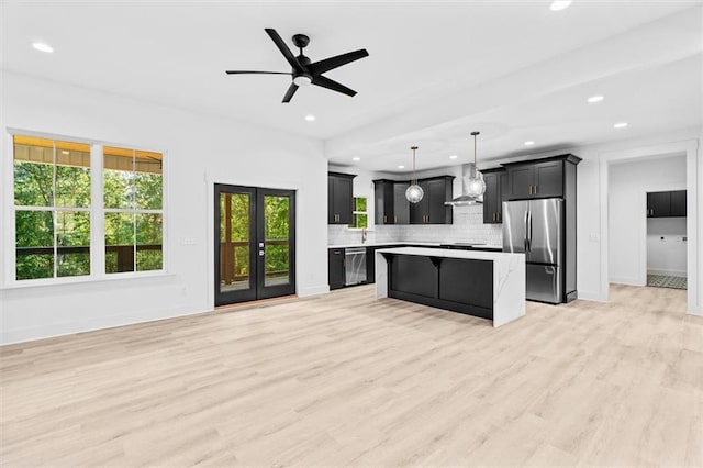 kitchen with a kitchen island, light hardwood / wood-style flooring, hanging light fixtures, stainless steel appliances, and ceiling fan