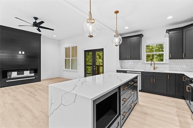 kitchen with tasteful backsplash, a center island, sink, and plenty of natural light