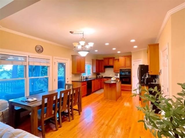 dining area with a chandelier, light hardwood / wood-style floors, and ornamental molding