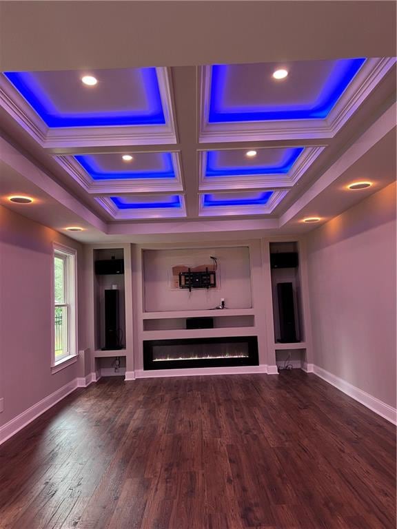 cinema with coffered ceiling, ornamental molding, dark hardwood / wood-style floors, and beamed ceiling