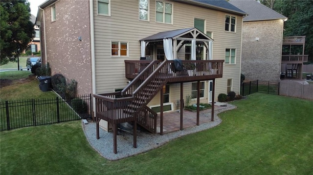 back of property with a gazebo, a deck, and a lawn